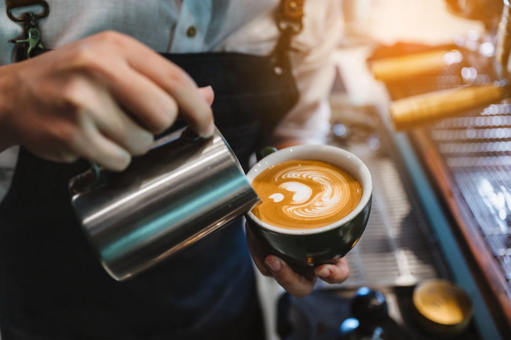 barista pouring latte