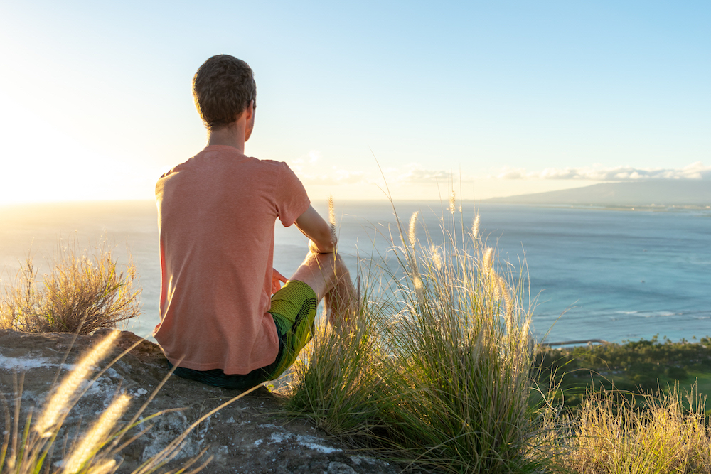 man at top of Diamond Head Crater looking out over the ocean